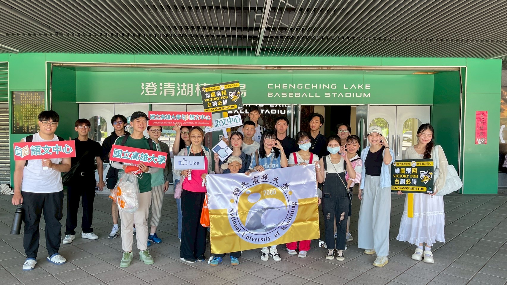 NUK students and staff holding university and cheering signs at the stadium